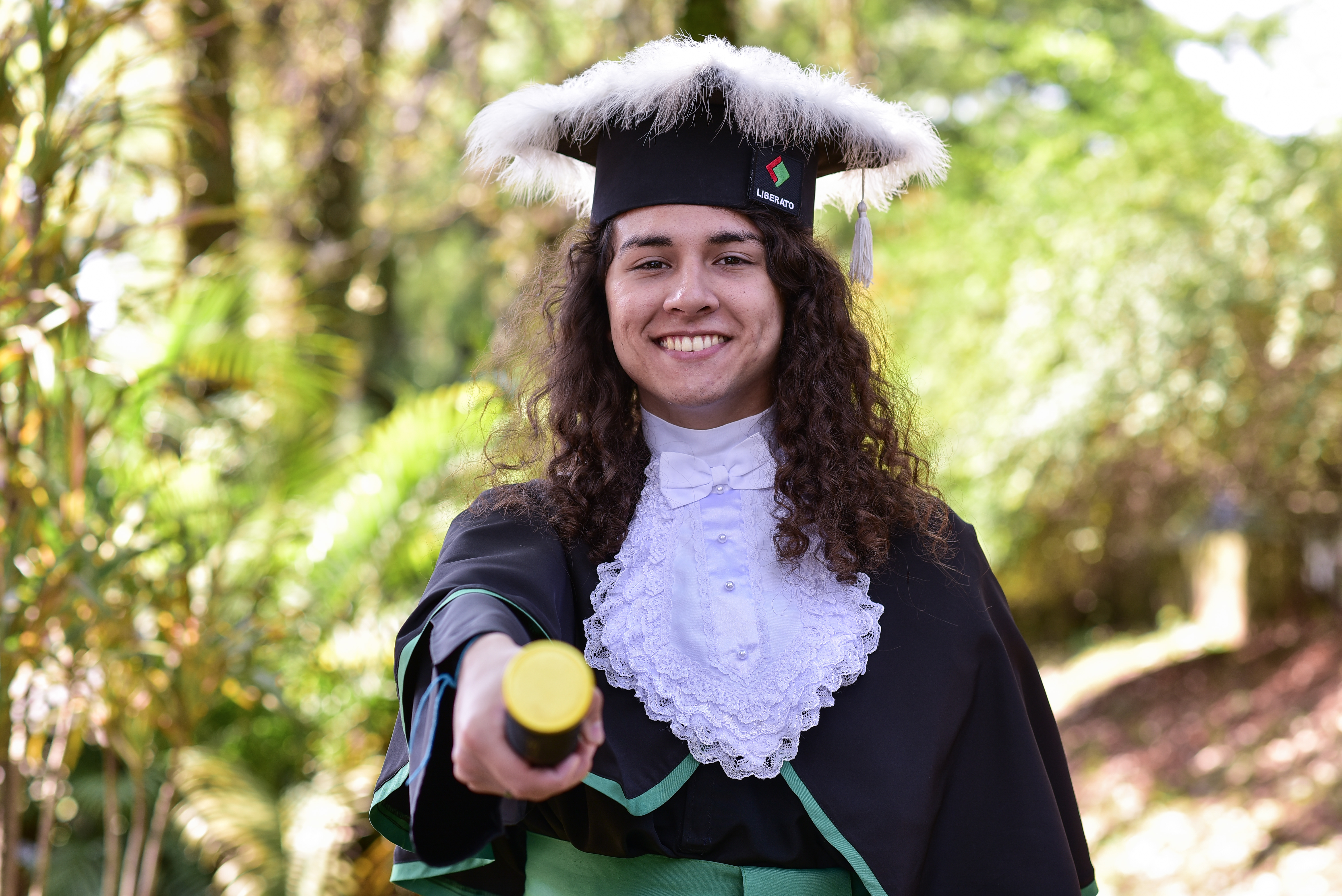 Luís dressed for graduation with diploma