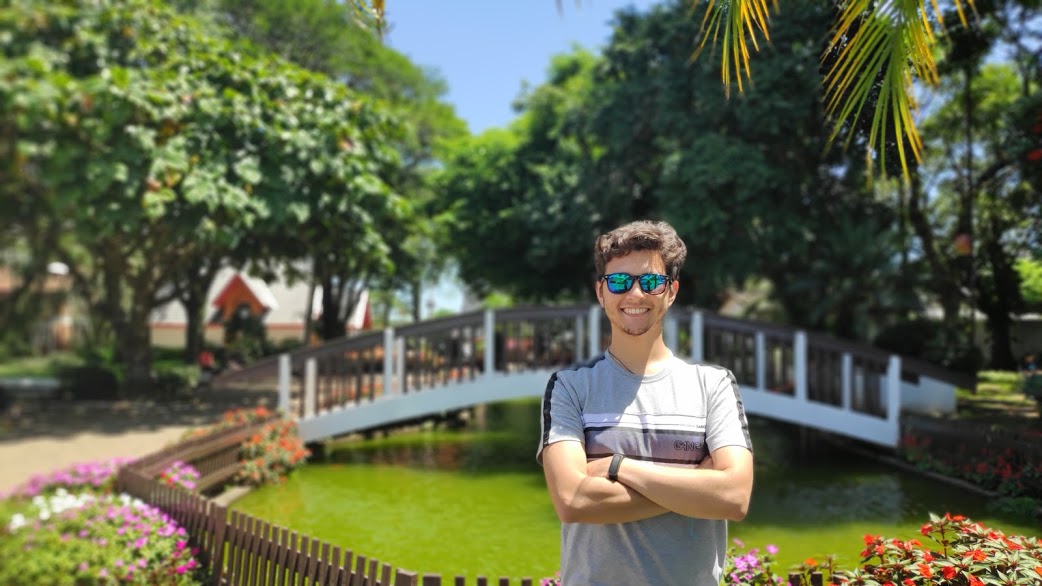 Luís with crossed arms in front of a fountain